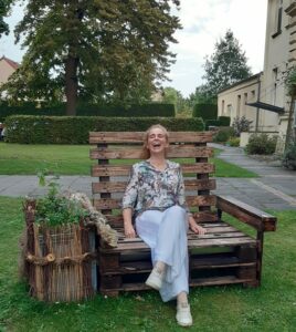 Elena Deppe auf einer Holzbank im Grünen